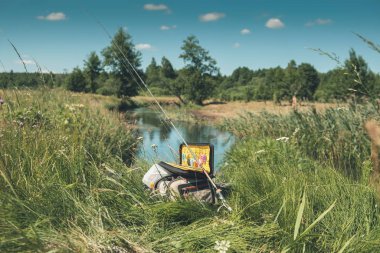Riverside, balık temelleri ile güneşli günde çanta