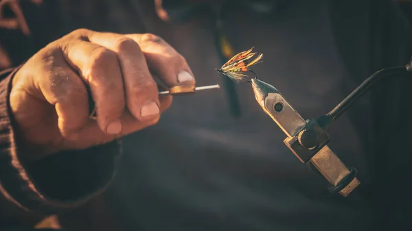 Primo piano del pescatore che lega una mosca per la pesca — Foto Stock