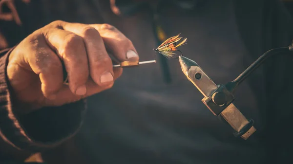 Balıkçılık için bir sinek bağlama balıkçı yakın
