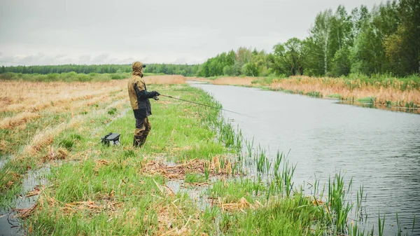 Pescatore con un bastone sul fiume sorgente . — Foto Stock