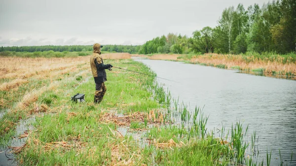 Рибалка зі стрижнем на весняній річці . — стокове фото