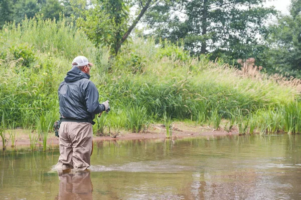 Angeln in den Watvögeln. Fischer auf einem Waldfluss. — Stockfoto