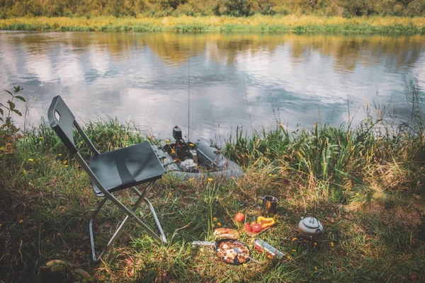 Maak de lunch klaar op de oever van de rivier. Vissen vanaf een boot. — Stockfoto