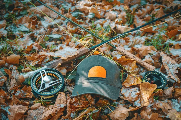 Sombrero, caña y carrete para la pesca con mosca, sobre el fondo de las hojas de otoño . —  Fotos de Stock