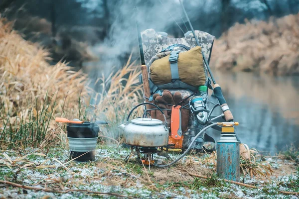 Yürüyüş gezisinde kahve hazırla. Gaz ocağı ve kaynar su ısıtıcısı. Sırt çantasındaki balık malzemeleri.. — Stok fotoğraf