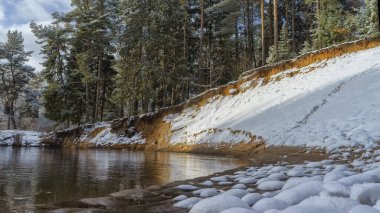 Kış karla kaplı orman nehri.