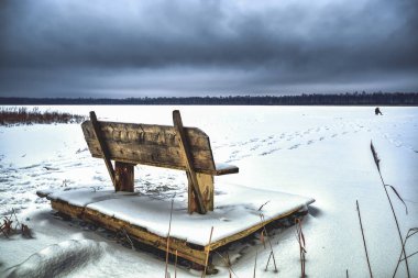 Donmuş kış gölünde yalnız bir balıkçı. Kış balıkçılık.