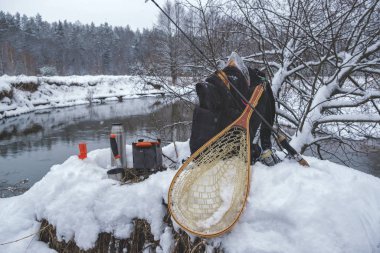 Balığa, karla kaplı Kış nehir pikniğe.