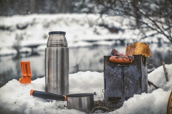 在冰雪覆盖的冬日里, 在钓鱼之旅上野餐. — 图库照片
