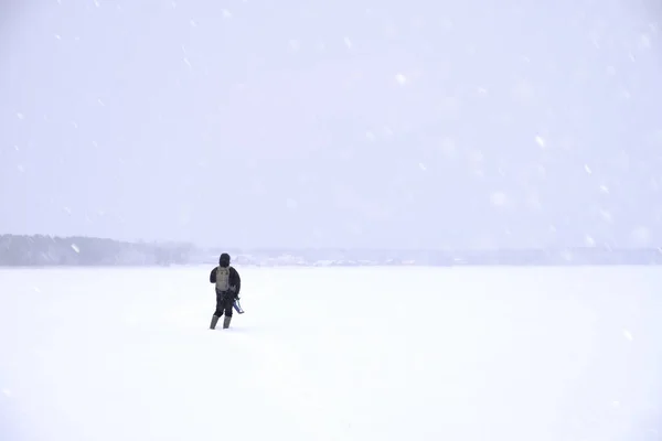 Pescador para fora na extensão nevada do lago. Pesca de Inverno — Fotografia de Stock
