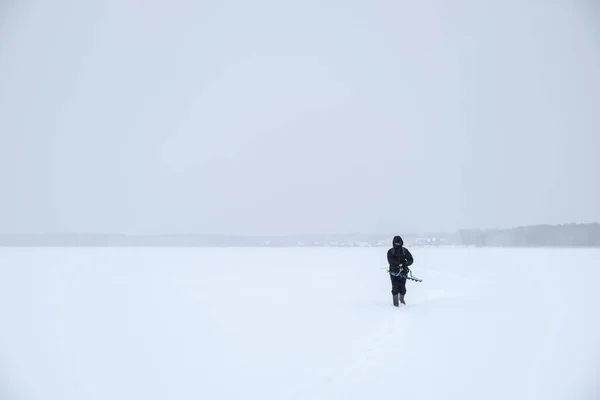 Pescador para fora na extensão nevada do lago. Pesca de Inverno . — Fotografia de Stock