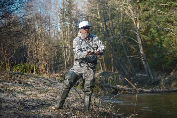 Pêcheur tenant une canne sur la rivière de la forêt . — Photo