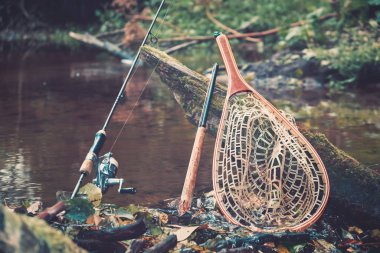 Bahar nehrinin arka planında balıkçılık malzemeleri.