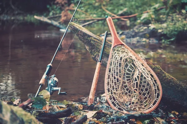 Bahar nehrinin arka planında balıkçılık malzemeleri. — Stok fotoğraf