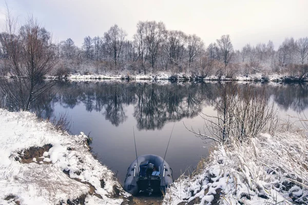 Barco de pesca inflável na margem de um rio de inverno . — Fotografia de Stock