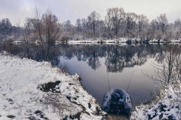 Barco de pesca inflável na margem de um rio de inverno . — Fotografia de Stock