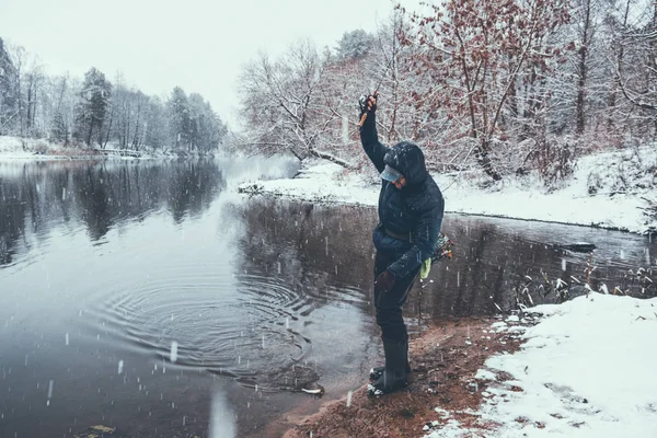 Pescador pegou um poleiro em um rio de inverno . — Fotografia de Stock