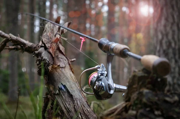 Spinning rod with a reel spring on the background of wood. — Stock Photo, Image