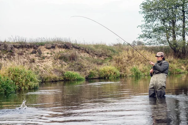 Happy fisherman pulls a fish . — ストック写真