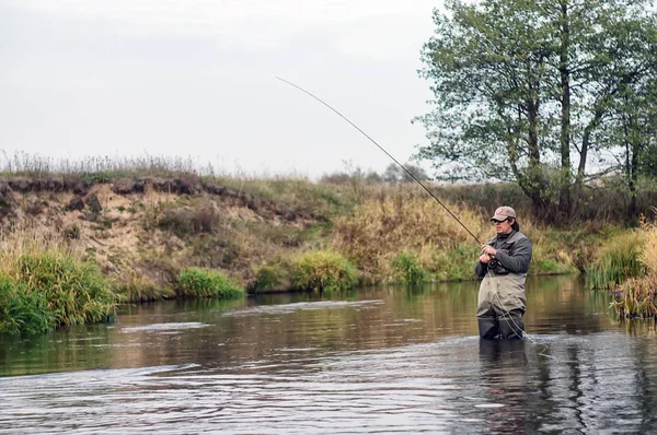 Glücklicher Fischer zieht einen Fisch . — Stockfoto