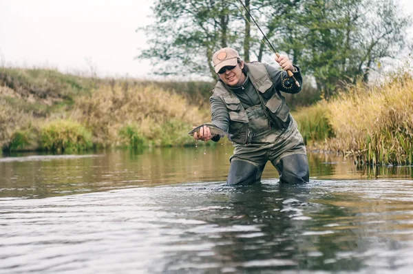 Happy fisherman pulls a fish . — ストック写真