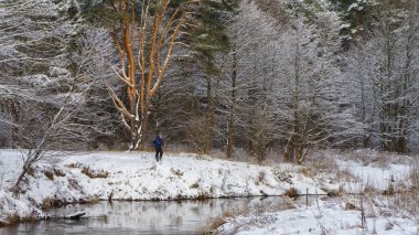 Balıkçı kış, karla kaplı Nehri üzerinde.