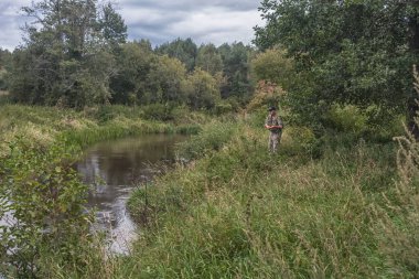 Küçük bir orman nehrinin kıyısında balıkçı..
