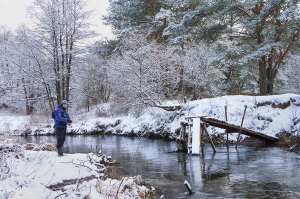 Pescador en invierno, el río cubierto de nieve . — Foto de Stock