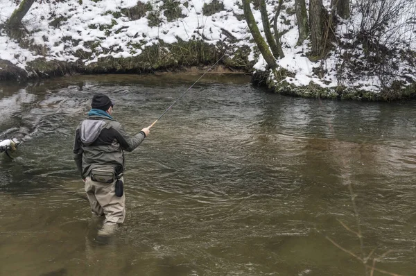Kış nehrinde oltalı bir balıkçı. Tenkara balıkçılık.