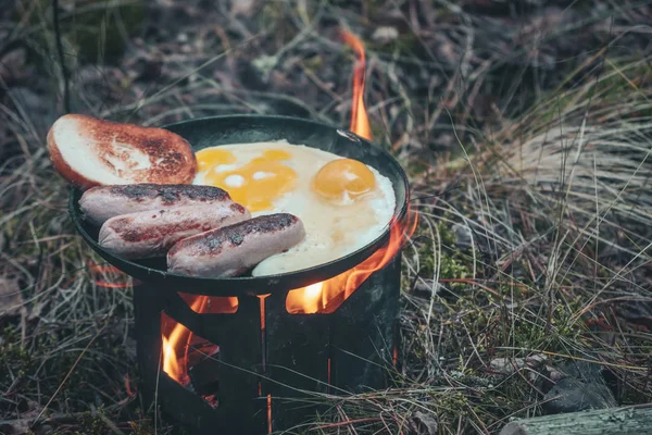 Cook on fire while hiking with a backpack.