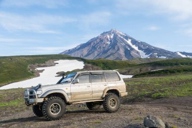KAMCHATKA PENINSULA, RUSSIA - 08 AĞUSTOS 2018: Bir volkanın arka planında Toyota Land Cruiser