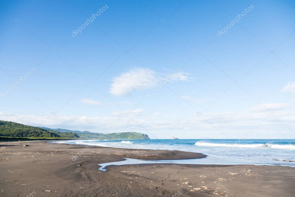 Wild beach made of volcanic sand on the Pacific Ocean, Kamchatka Peninsula, Russia.