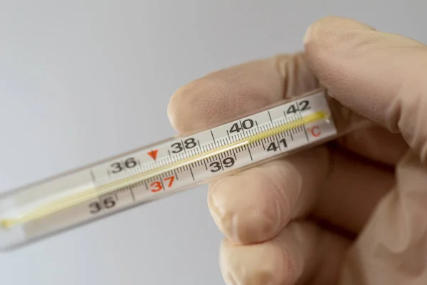 High body temperature. Mercury thermometer in the hands of a nurse. Body temperature measurement. — Stock Photo, Image