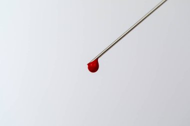 Kan örneğiyle birlikte şırınga. İğnenin ucunda bir damla kan var. Kan kimyası. Virüsler için kan testi.