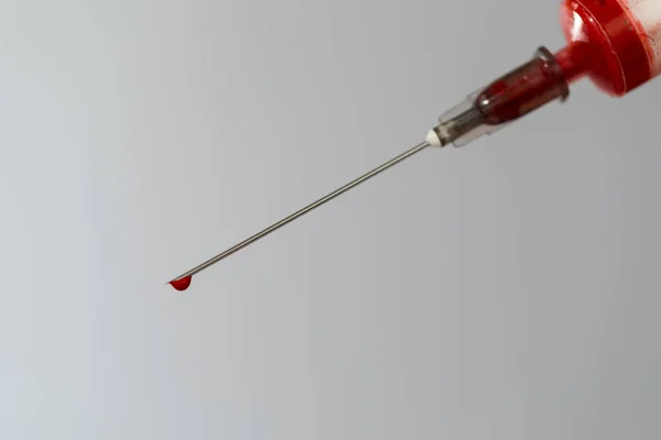 Strzykawka z próbką krwi. Kropla krwi na końcu igły. Chemia krwi. Badanie krwi na obecność wirusów. — Zdjęcie stockowe