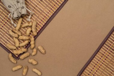 Fındık, kabuklu fıstık, masa üzerine keten poşet serpiştirme, kraft kağıdı arka plan. Telif alanı olan üst görünüm, düz yatay.