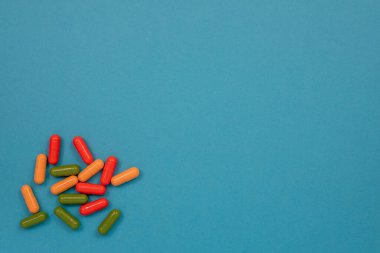 Çok renkli haplar masanın üzerine saçılmış. Kopyalama alanı olan üst görünüm, düz yatay.