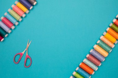 Çok renkli pamuk iplikler, makaralar, makas, el yapımı dikiş. Telif alanı olan üst görünüm, düz yatay.