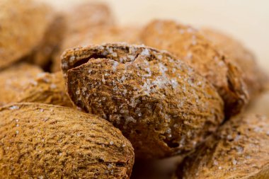 Soyulmamış bademler ahşap bir masanın üzerine yakın plan. Kaçık. Sağlıklı yiyecekler.