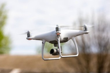 Gökyüzü arka planında yüksek çözünürlüklü dijital kamerası olan drone kuadrokopteri.