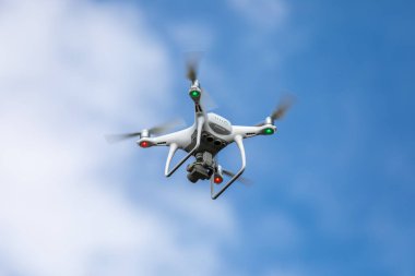 Gökyüzü arka planında yüksek çözünürlüklü dijital kamerası olan drone kuadrokopteri.