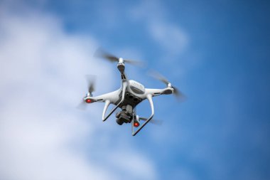 Gökyüzü arka planında yüksek çözünürlüklü dijital kamerası olan drone kuadrokopteri.