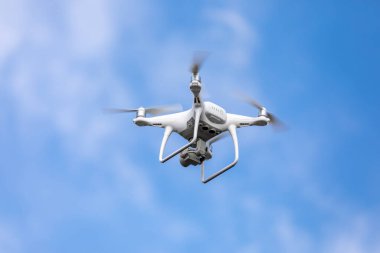 Gökyüzü arka planında yüksek çözünürlüklü dijital kamerası olan drone kuadrokopteri.
