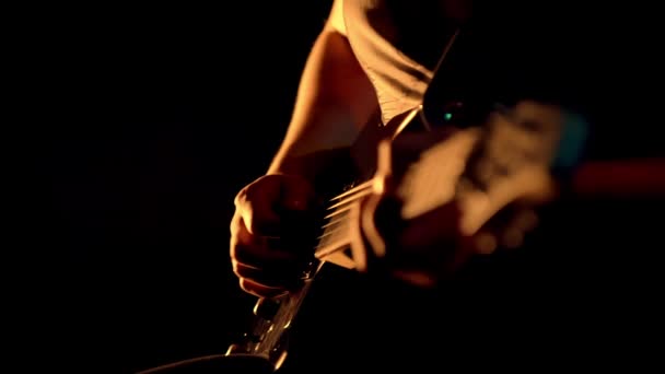 Human hands playing on electric guitar. Close up of rock musician playing guitar on stage with scenic illumination. Bassist playing electric bass guitar. Fingers on guitar strings — Stock Video