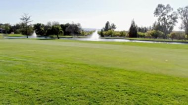 Yakışıklı yaşlı golfçü golf sahasında sallanıyor ve topa vuruyor.
