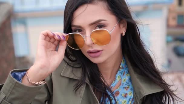Divatos életmód portré csinos nő a napszemüvegben pózol a város őszi tetőjén. street fashion — Stock videók