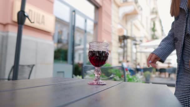 在街上的咖啡店里，一位年轻貌美、优雅、性感的女士与一杯葡萄酒的特写 — 图库视频影像