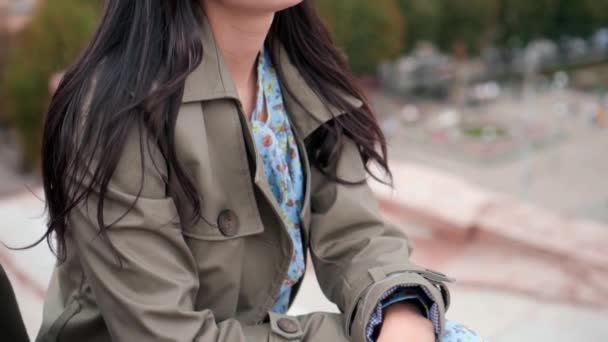 Atractiva joven en vestido de moda, abrigo verde y gafas de sol amarillas sentada sola en el techo en el día de otoño. Acción. Estilo urbano moderno — Vídeo de stock