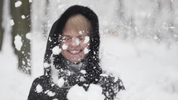 Unga kvinnor njuter av vinterdagen utomhus. snövinterdröm. slow motion. Glad lycka snön flyger på en ung lycklig kvinna — Stockvideo