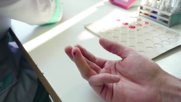 Esame del sangue delle dita. Primo piano delle mani in guanto che prelevano campioni di sangue. Primo piano degli esami del sangue. Infermiera che preleva sangue dalla mano maschile. Test medici hiv — Video Stock